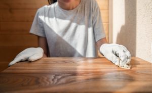 A,Young,Girl,In,Work,Gloves,Is,Covering,A,Wooden